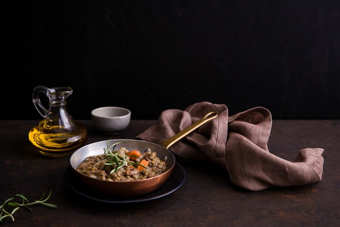 Rustic pan of cooked food, surrounded by food photography props