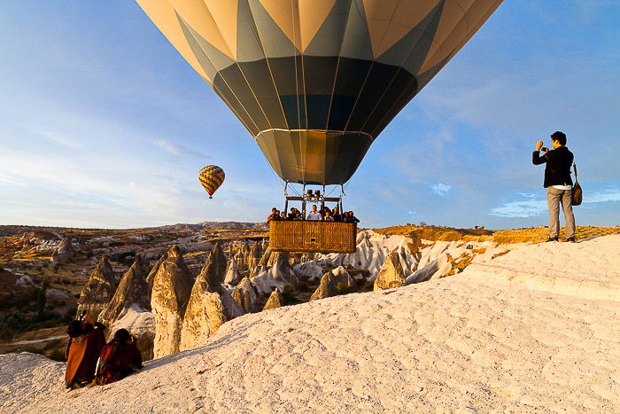 Photographers taking hot air balloon pictures of a balloon just taking off