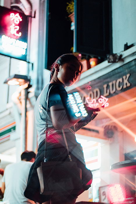 A portrait of a female model surrounded by neon signs