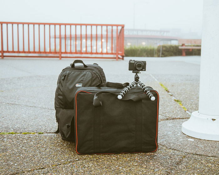 A camera on a small tripod on suitcases