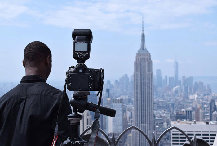 A DSLR set up on a tripod to photograph a cityscape