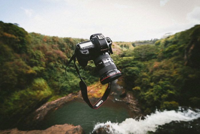 A DSLR camera falling through the air over an impressive landscape