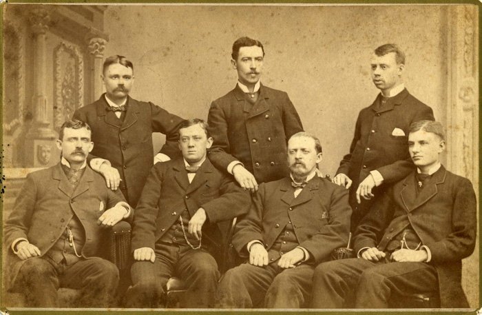 An old group photo of seven men illustrating why didn't people smile in old photos