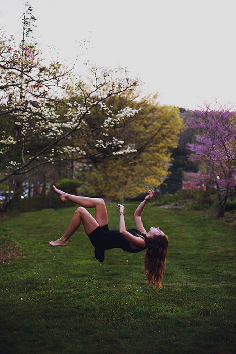 A conceptual portrait of a female model levitating in a garden