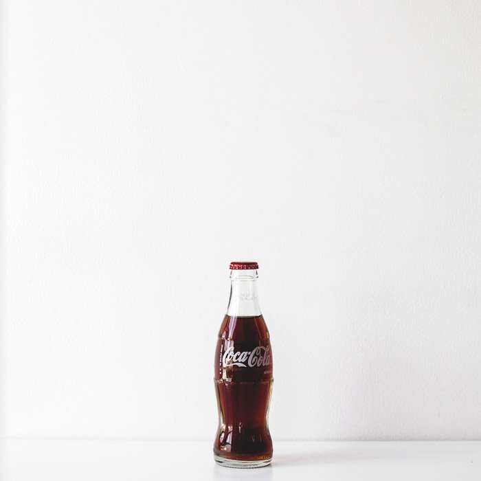 A product photography shot of a bottle of cola on white background