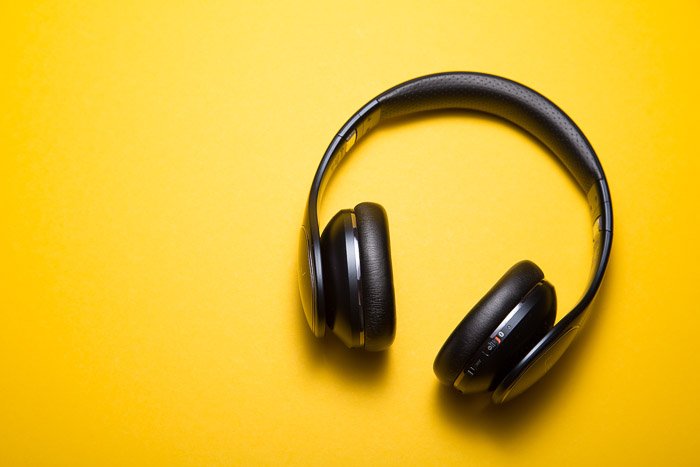 A product photography shot of headphones on yellow background