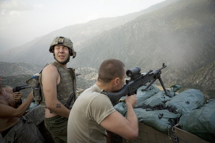 Soldiers aiming guns towards the mountains, war photography by Tim Hetherington