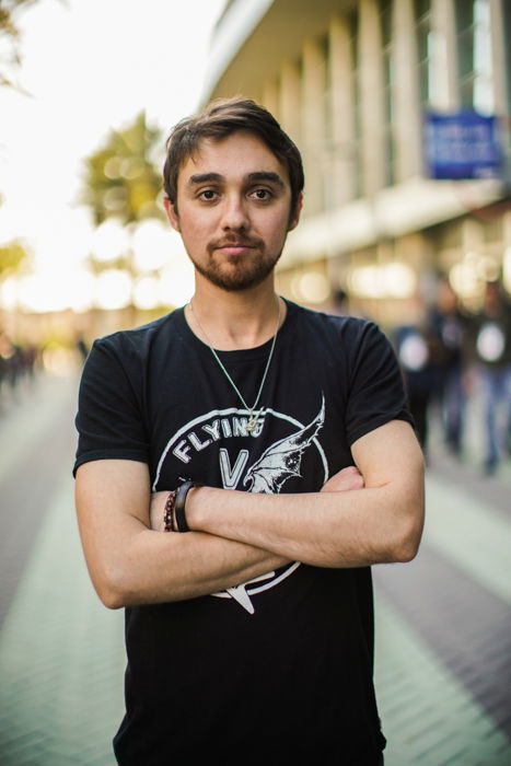 A portrait of a male model posing with folded arms on a street - stock photos of people 