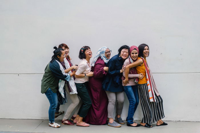 A stock portrait of seven women standing in a conga line pose - bad stock photos