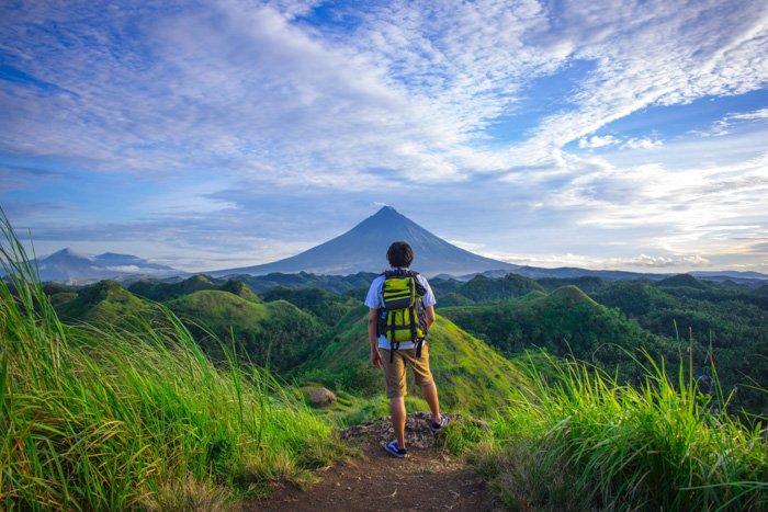 A portrait of a backpacker gazing onto a breathtaking mountainous landscape