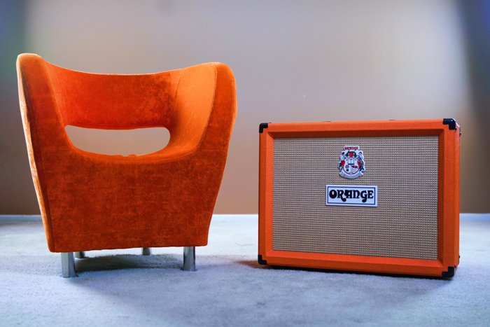 A product photography shot of an orange amp beside an orange chair - photography copyright