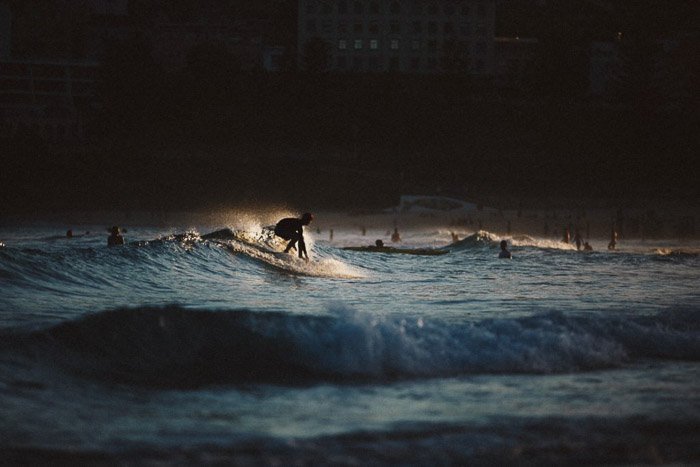 A person surfing in low light