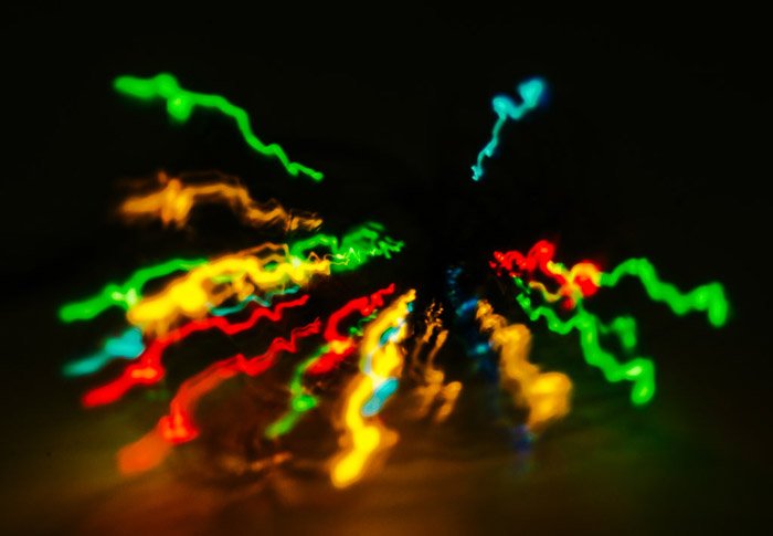 A creative zoom burst photo of colored fairy lights against black background