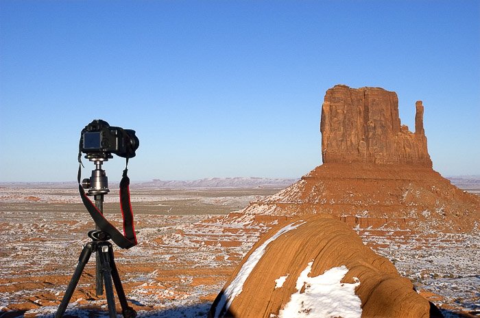 A Dslr camera set up on a tripod in a rocky landscape - different camera parts explained