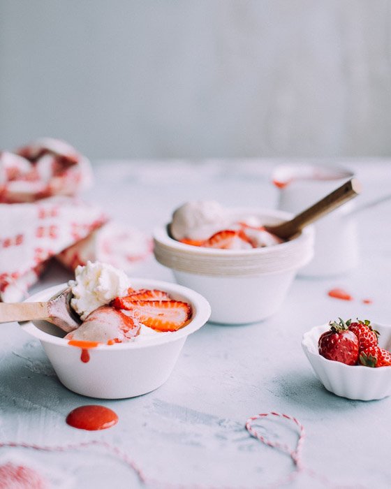 Bowls of strawberrys and ice-cream against a white background - food photography examples 
