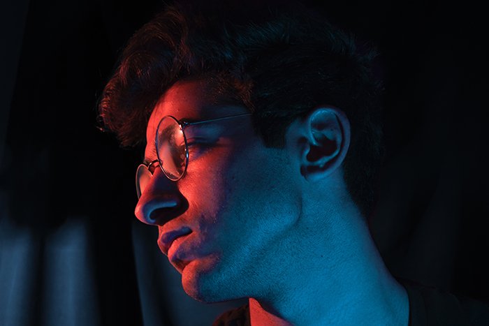An atmospheric neon photography portrait of a male model in low light - neon photography tips