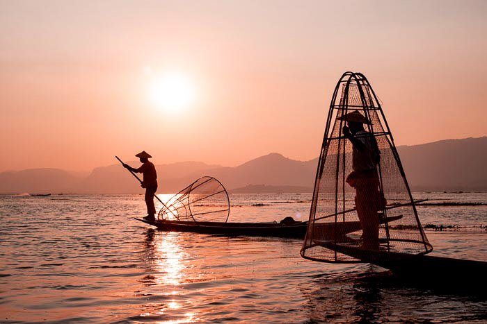 A portrait of fishermen on Inle Lake in Myanmar at sundown