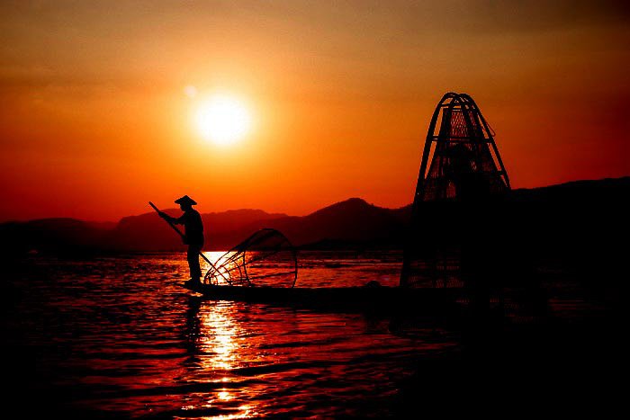 A portrait of fishermen on Inle Lake in Myanmar at sundown 