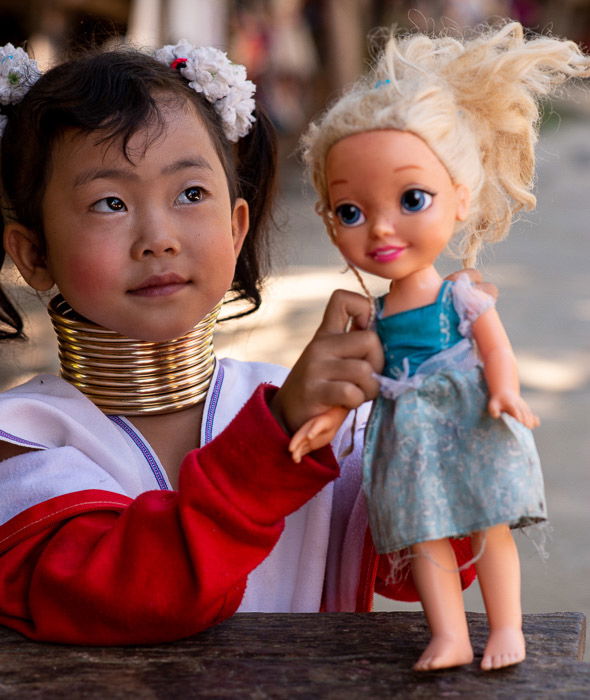 A young karen girl holding a plastic doll 