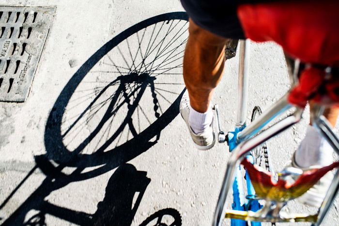 A close up of shadows cast from a person on a bike 