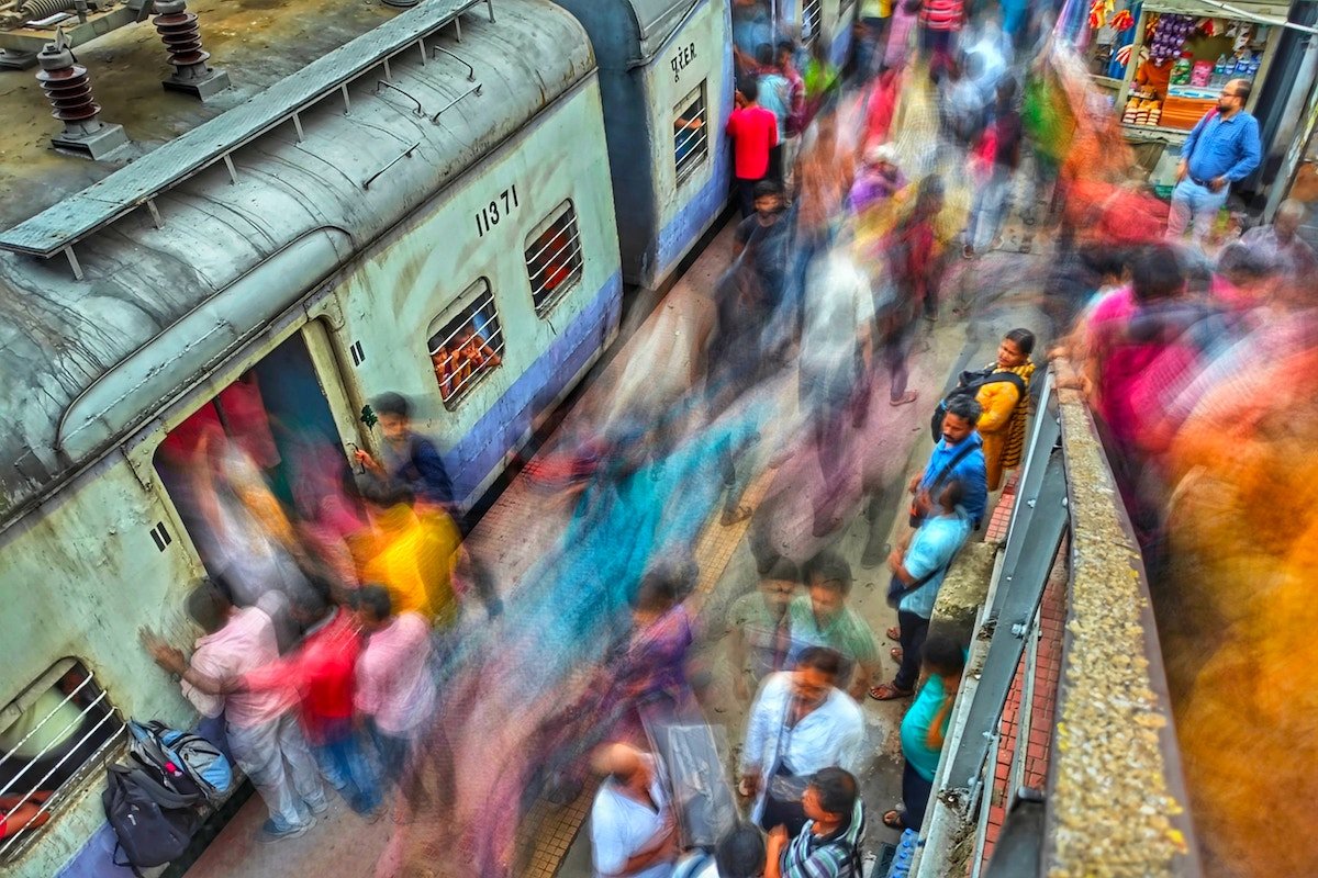 Colorful long exposure of people walking around a train platfrom