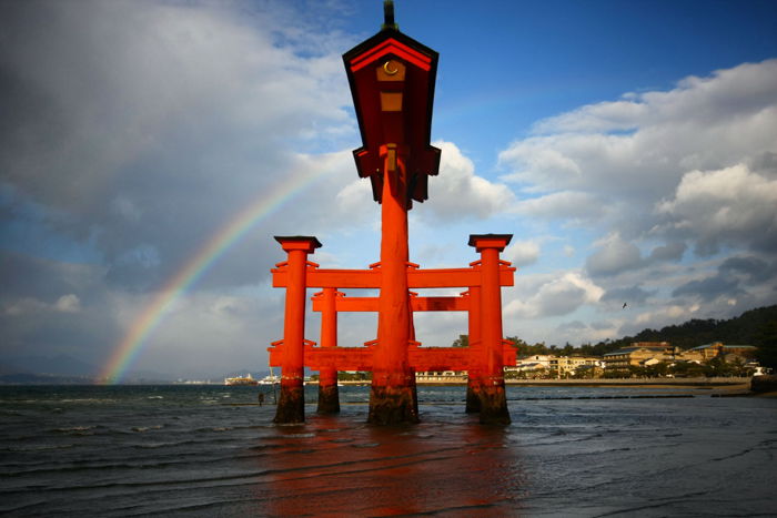 A stunning rainbow behind the famous gate on Miyajima island in Japan.