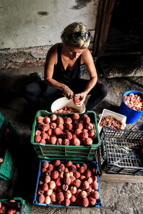 A portrait of a woman cutting fruit on the street