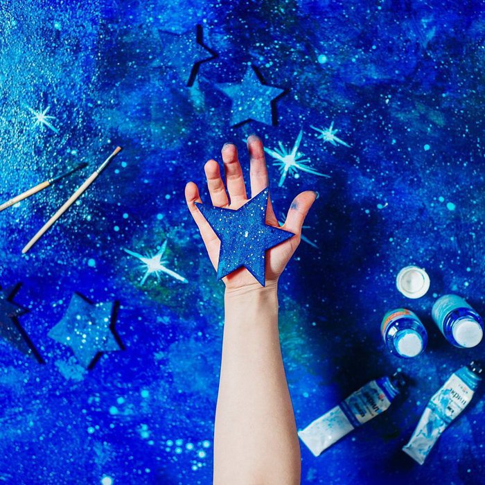 A creative spaced themed photography flat lay on a hand painted background 