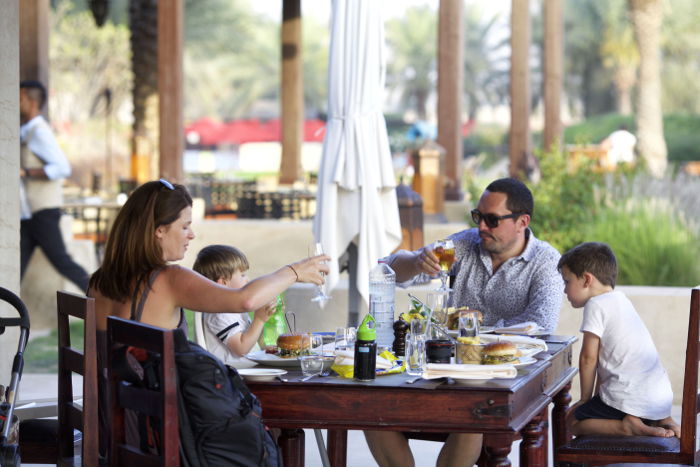 A family portrait eating dinner outdoors on holiday