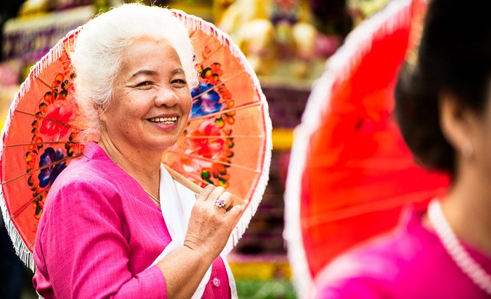 A colorful street portrait of an Elegant Senior Woman holding an umbrella - tips on using photos that tell a story