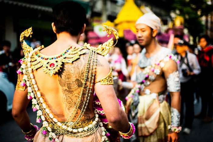 Dressed in a traditional costume a young man waits for the flower parade to start in Chiang Mai, Thailand. Narrative photography