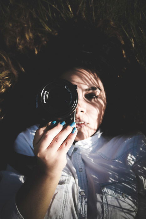 Atmospheric portrait of a female photographer lying on her back