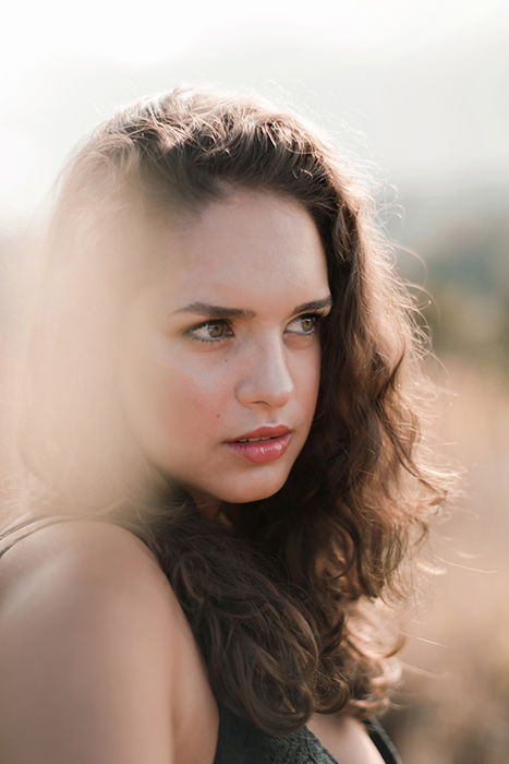 Retrato sonhador de um modelo feminino posando ao ar livre, com borrão de movimento etéreo