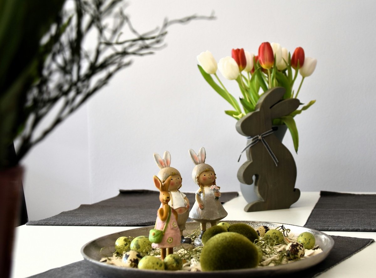 A still life with figurines on a tray and tulips in a bunny vase as an example for Easter picture ideas