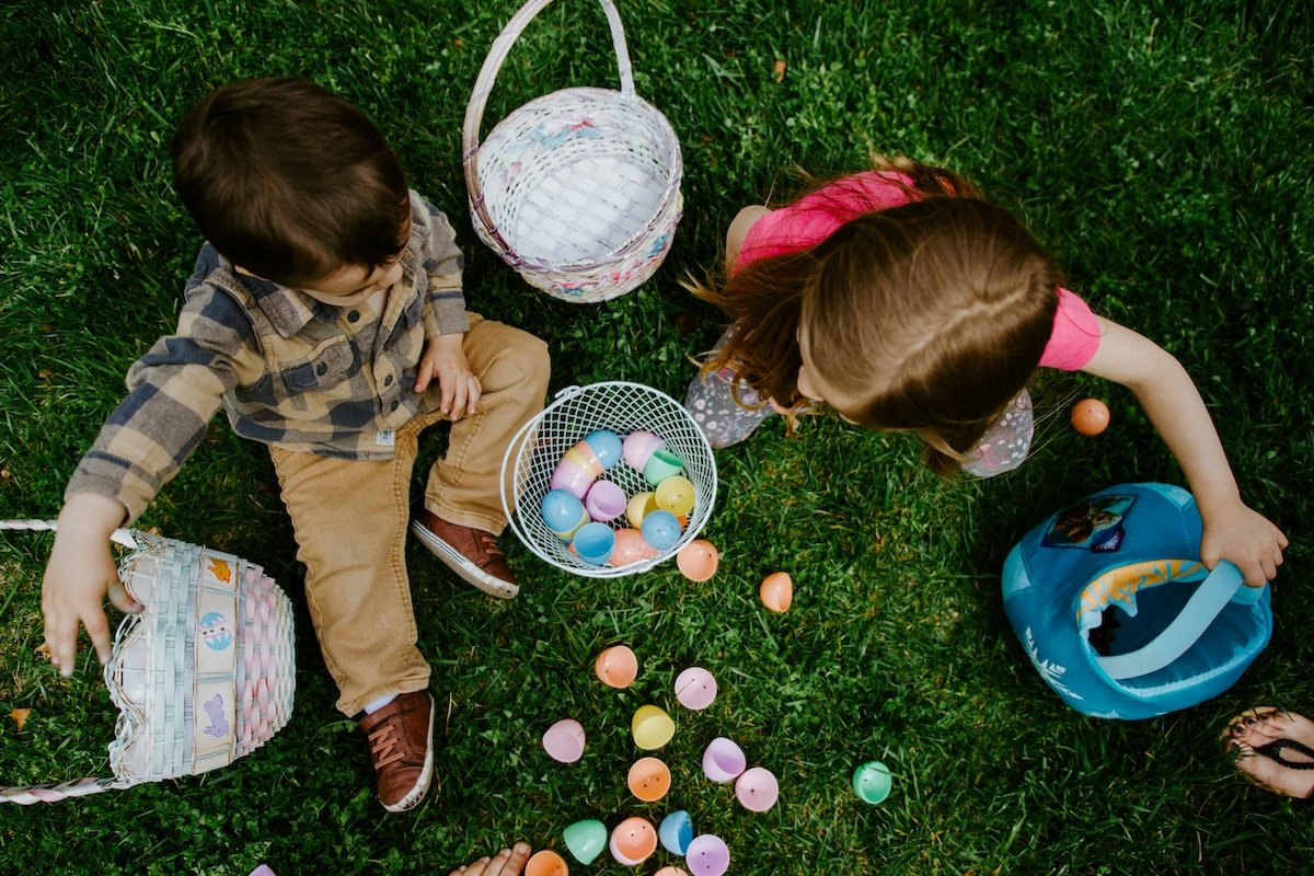 Two kids with baskets and colored eggs shot from above as an example for Easter picture ideas