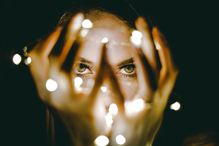 Atmospheric portrait of a female model holding a string of lights - fairy light photography 