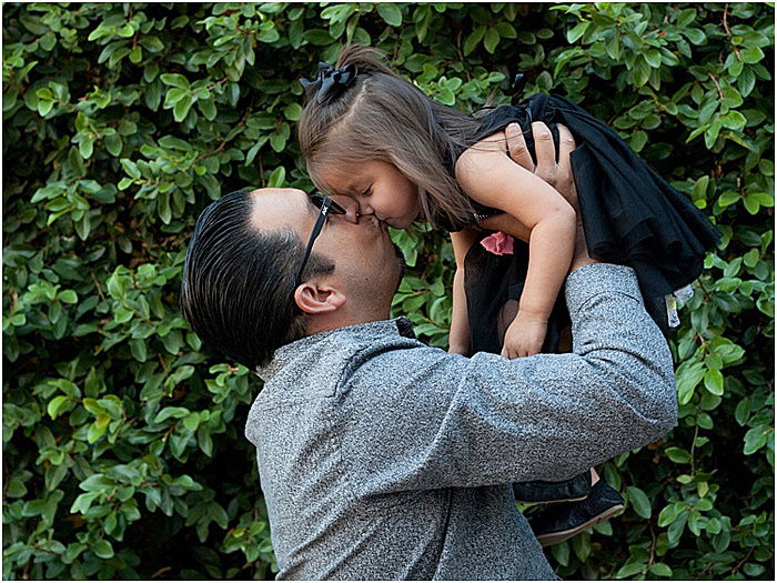 A sweet family portrait of a father and daughter playing outdoors