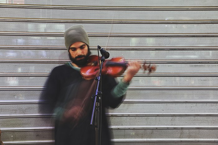 Blurry portrait of a street performer playing violin - fine art photography mistakes 