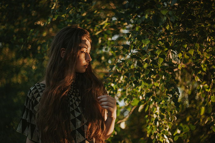 Atmospheric self portrait of a female model posing outdoors surrounded by trees - fine art photography mistakes