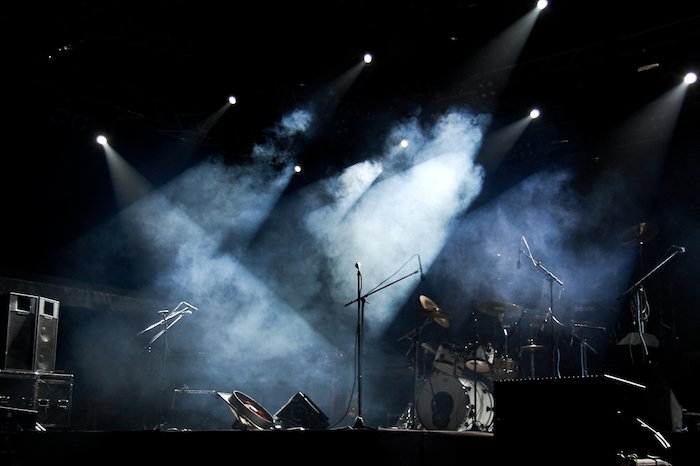Empty concert stage with smoke and white spotlights on