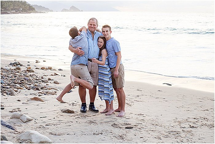 A fun and casual portrait of a family of four posing on the beach - emotional photography