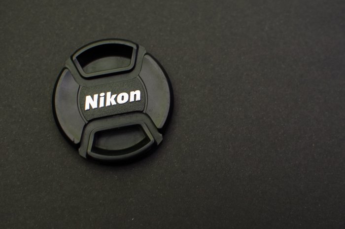 A Nikon lens cap on grey background - how to use a grey card for color balance