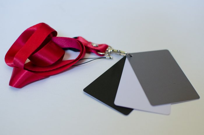 A small set of photography grey cards on a pink ribbon