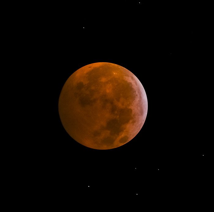 Blood Moon, during totality. Stars can be seen in the sky around the Moon.