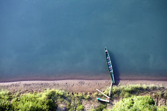 An aerial view of a small boat in a coastal minimal landscape