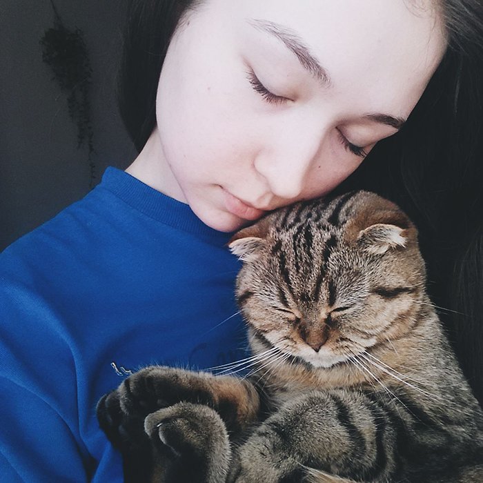 A sweet portrait of a female model posing with a tabby cat - smartphone pet photography