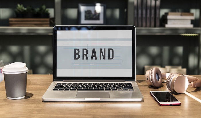 A laptop in a home office with the word 'brand' large onscreen 