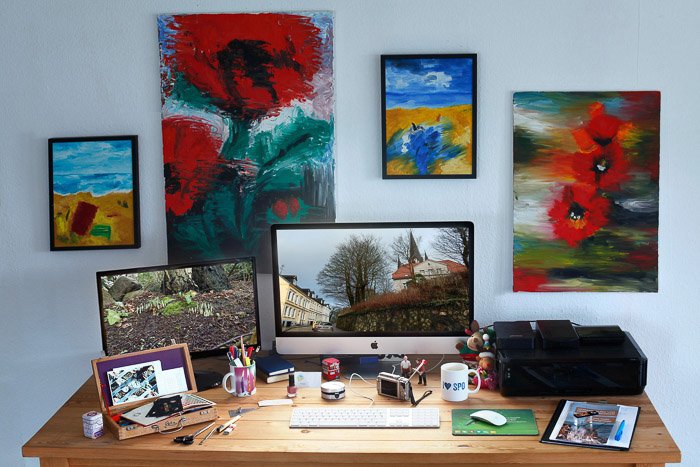 A home office desk surrounded by colorful paintings - color mode in photoshop