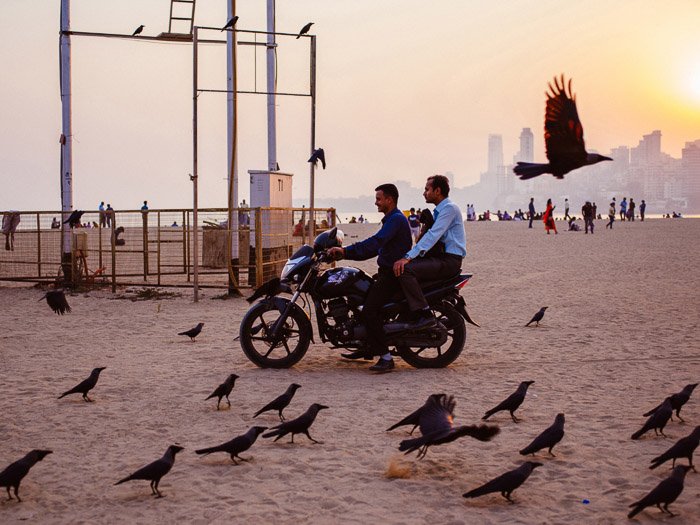 A photo of people on motorbikes on a beach in Bombay - How to Use Smart Objects in Photoshop