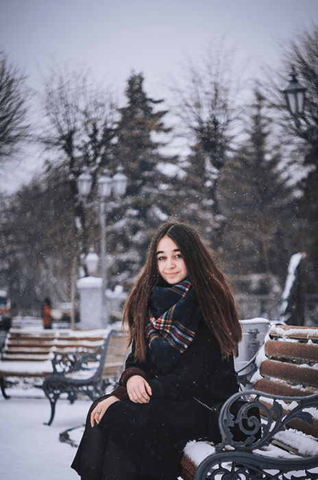 Free Photo | Woman watches how snow falls down on her face while she poses  on the winter mountain